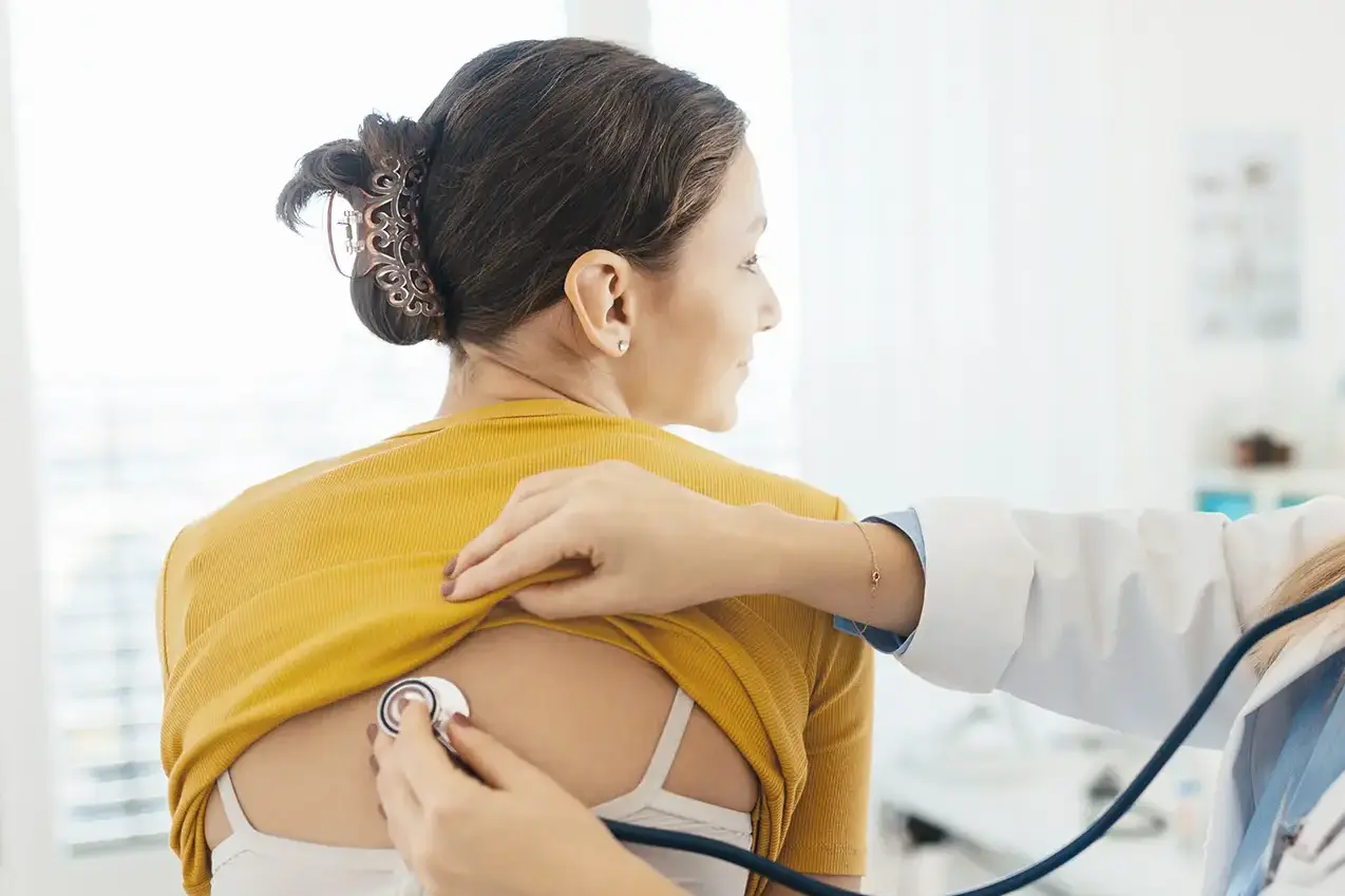 Teenagerin wird bei der Untersuchung von der Ärztin abgehört